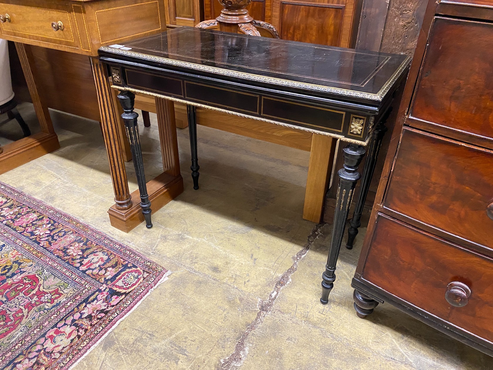 A late 19th century French gilt metal mounted ebonised rectangular folding card table, width 90cm, depth 45cm, height 76cm
